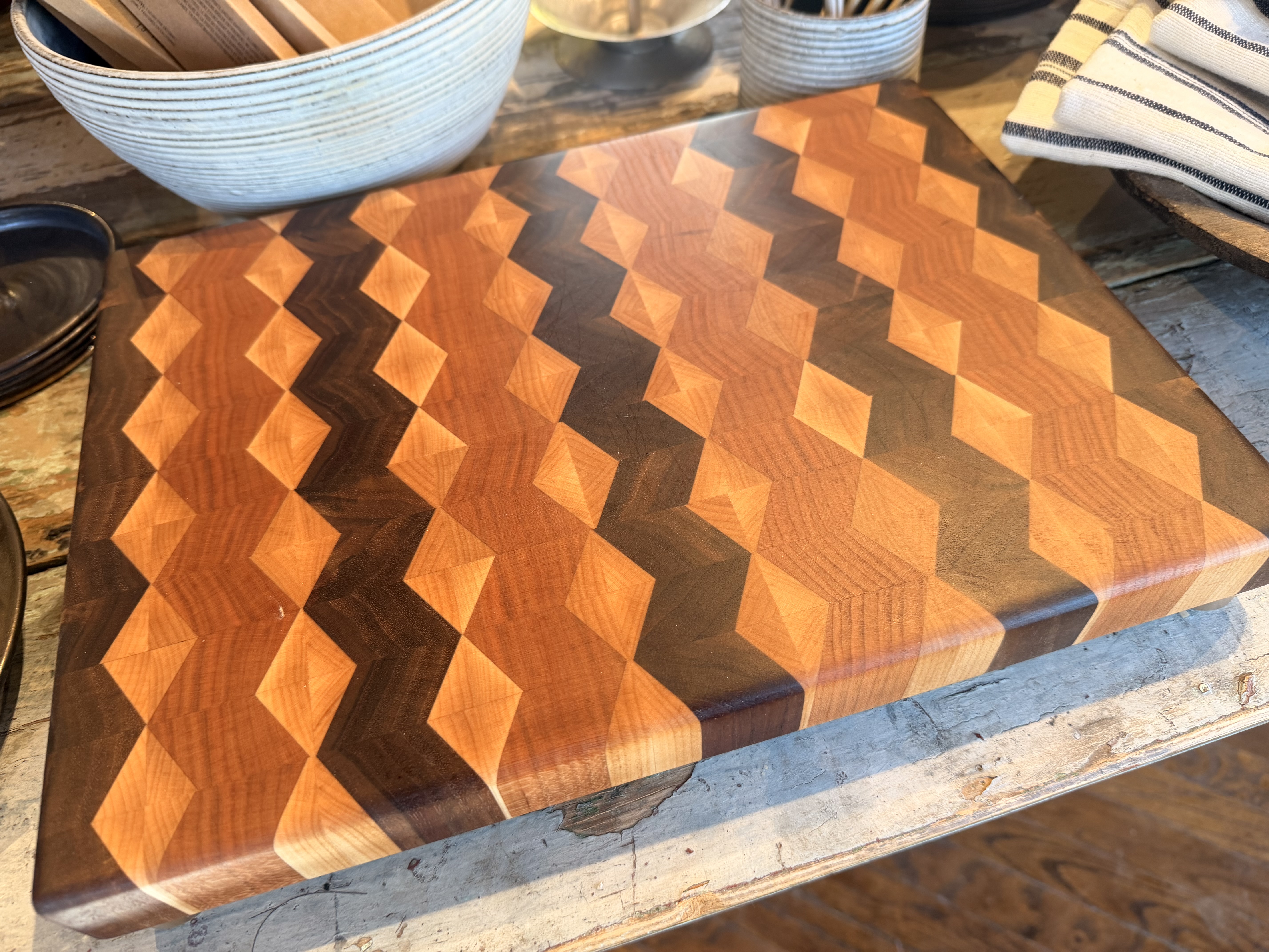 A Cutting board with a diamond pattern made from Walnut, Maple and Cherry lumber